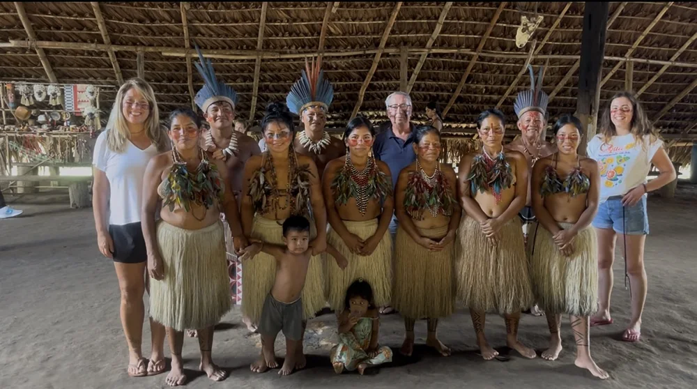 Grupo de visitantes no interior de uma oca